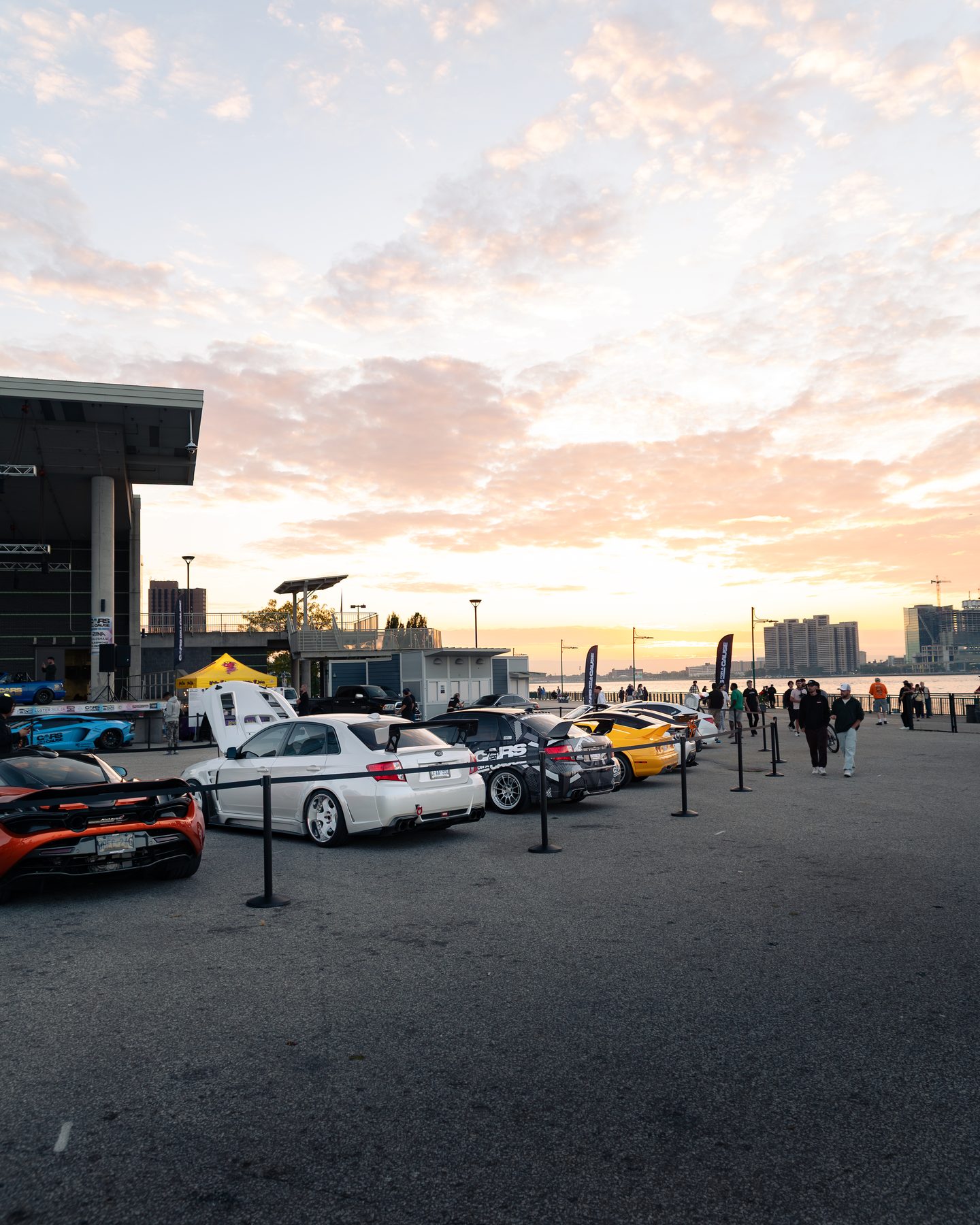 Cars lined up along the Windsor riverfront at sunset during a past Cars for a Cause event